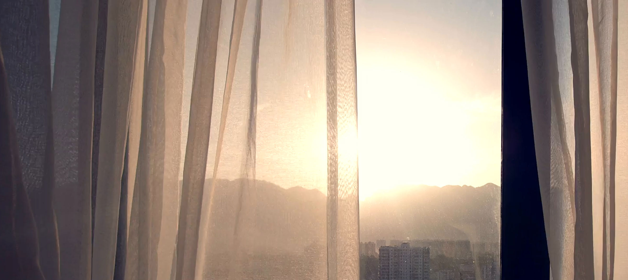 Sunset view from a room with curtains