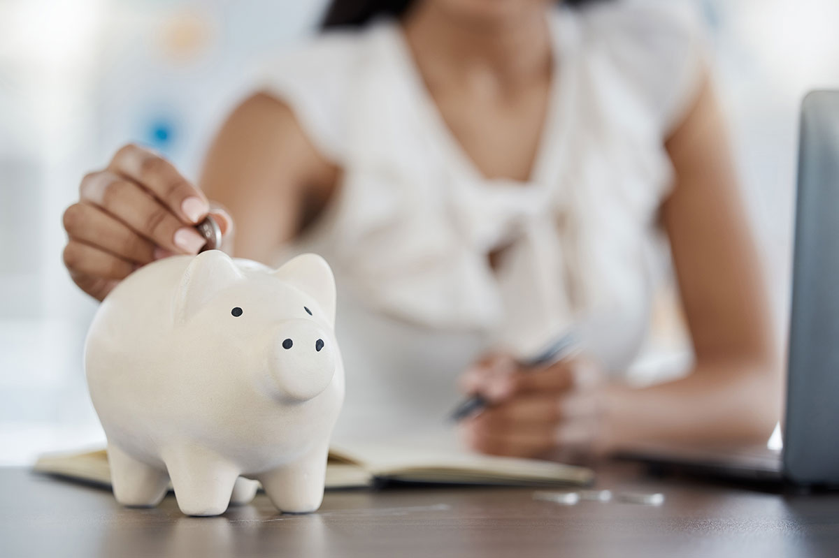 Woman putting money in a piggy bank